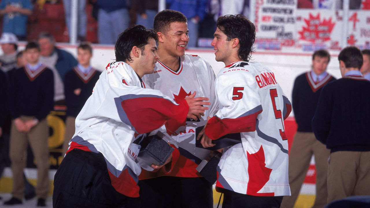 On the ice, Canadian hockey players Jose Theodore, Jerome Ignila, and Nolan Baumgartner celebrate Team Canada's victory at the 1996 World Junior Ice Hockey Championships in Alberta, Canada, 1996.