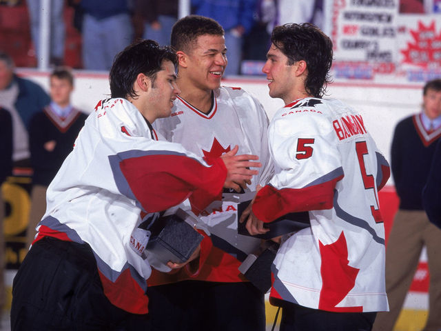 On the ice, Canadian hockey players Jose Theodore, Jerome Ignila, and Nolan Baumgartner celebrate Team Canada's victory at the 1996 World Junior Ice Hockey Championships in Alberta, Canada, 1996.