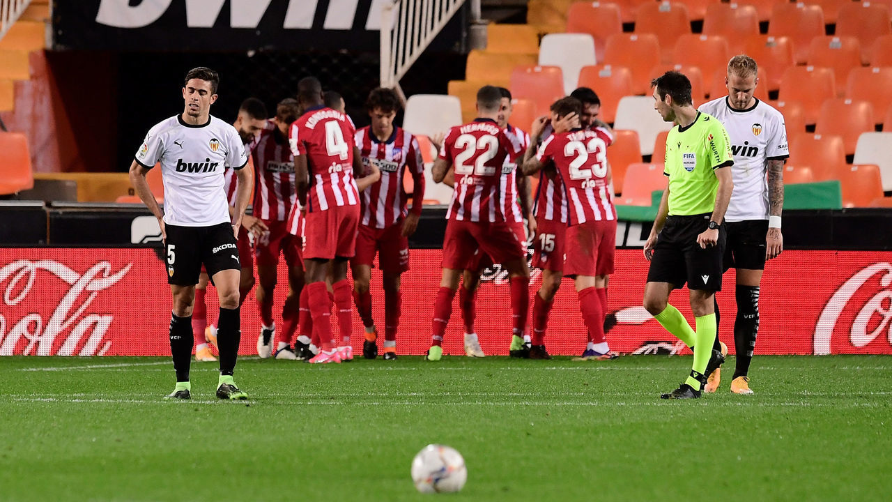Atletico players celebrate Valencia's Spanish defender Toni Lato's own goal during the Spanish League football match between Valencia and Atletico Madrid at the Mestalla stadium in Valencia on November 28, 2020.
