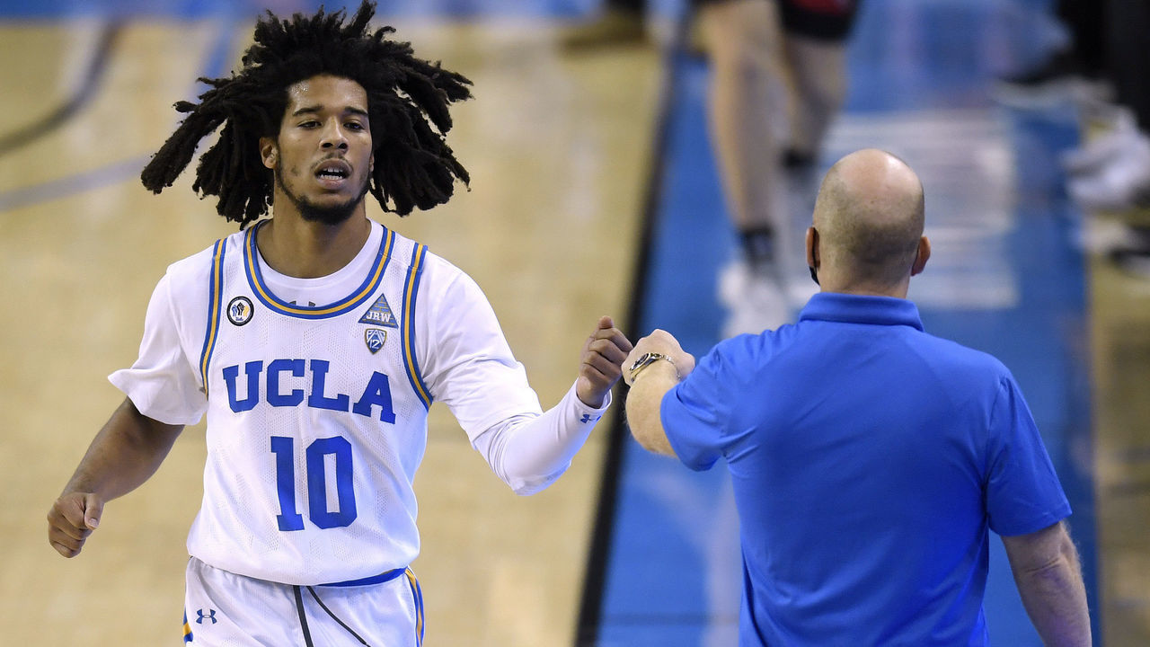 LOS ANGELES, CALIFORNIA - DECEMBER 03: Tyger Campbell #10 of the UCLA Bruins celebrates with head coach Mick Cronin as he leaves the game with a lead over the Seattle Redhawks during the second half in a 78-52 UCLA win at UCLA Pauley Pavilion on December 03, 2020 in Los Angeles, California.