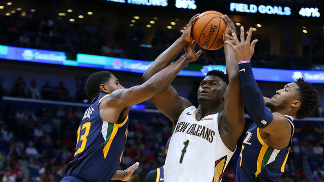 NEW ORLEANS, LOUISIANA - OCTOBER 11: Zion Williamson #1 of the New Orleans Pelicans is fouled by Royce O'Neale #23 of the Utah Jazz and Donovan Mitchell #45 during a game at the Smoothie King Center on October 11, 2019 in New Orleans, Louisiana.