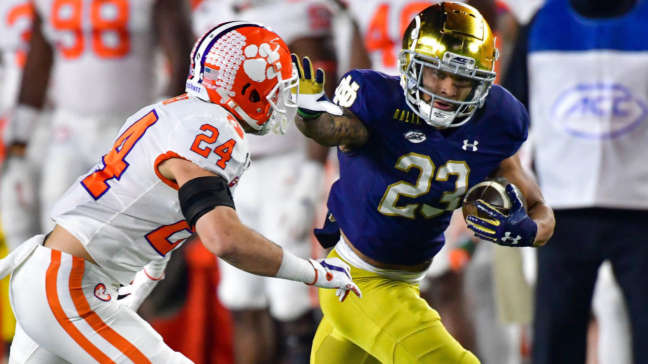 SOUTH BEND, INDIANA - NOVEMBER 07: Running back Kyren Williams #23 of the Notre Dame Fighting Irish stiff arms safety Nolan Turner #24 of the Clemson Tigers on his way to a touchdown in the first quarter at Notre Dame Stadium on November 7, 2020 in South Bend, Indiana.
