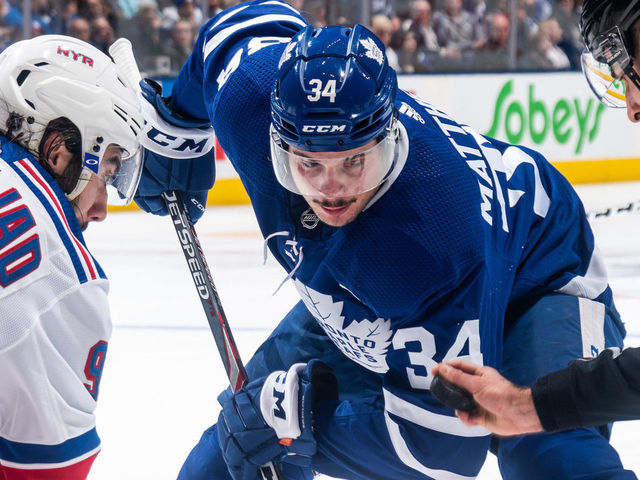 TORONTO, ON - DECEMBER 28: Auston Matthews #34 of the Toronto Maple Leafs takes a face off against Mika Zibanejad #93 of the New York Rangers during the second period at the Scotiabank Arena on December 28, 2019 in Toronto, Ontario, Canada.