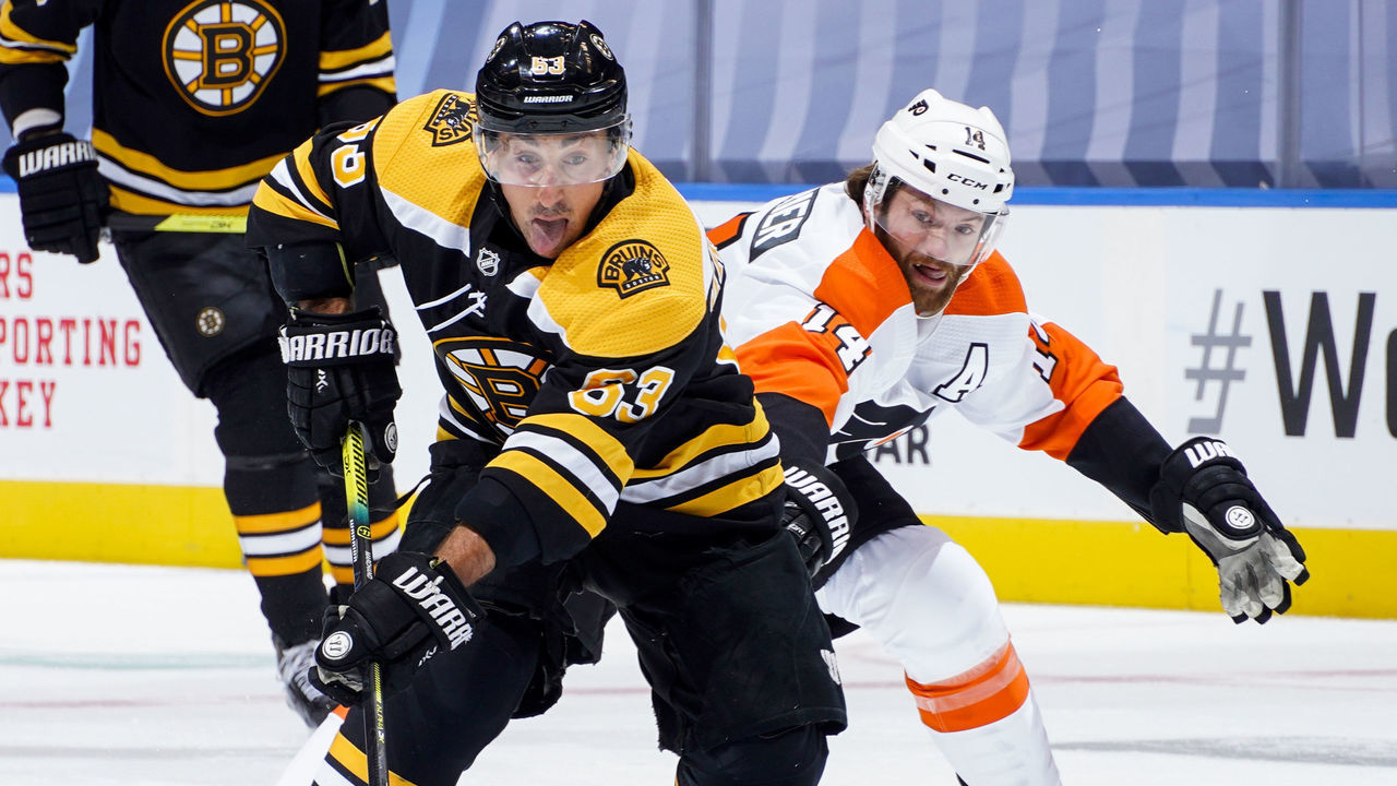 TORONTO, ONTARIO - AUGUST 02: Brad Marchand #63 of the Boston Bruins plays the puck against Sean Couturier #14 of the Philadelphia Flyers during the first period in a Round Robin game during the 2020 NHL Stanley Cup Playoff at Scotiabank Arena on August 02, 2020 in Toronto, Ontario.