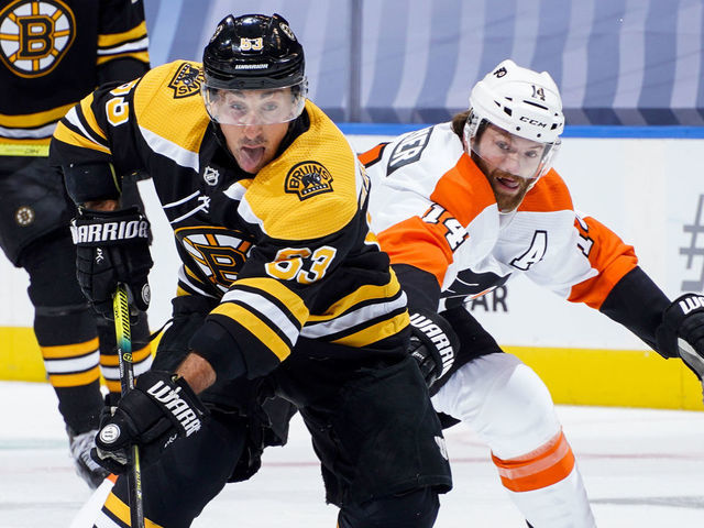 TORONTO, ONTARIO - AUGUST 02: Brad Marchand #63 of the Boston Bruins plays the puck against Sean Couturier #14 of the Philadelphia Flyers during the first period in a Round Robin game during the 2020 NHL Stanley Cup Playoff at Scotiabank Arena on August 02, 2020 in Toronto, Ontario.