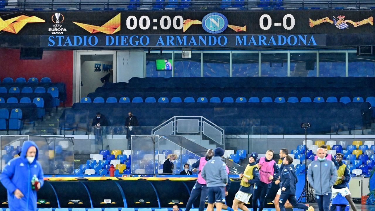 A sign reading "Diego Armando Maradona stadium" is pictured as players warm up prior to the UEFA Europa League Group F football match Napoli vs Real Sociedad on December 10, 2020 at the newly renamed Maradona stadium, formerly known as the San Paolo, in Naples, Italy.