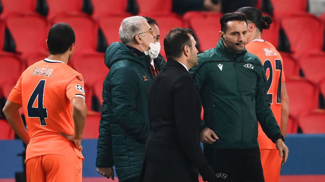 TOPSHOT - Istanbul Basaksehir's Turkish coach Okan Buruk (2ndR) talks to Romanian 4th referee Sebastian Coltescu (R) after the game was suspended in the first half as the players walked off amid allegations of racism by one of the match officials during the UEFA Champions League group H football match between Paris Saint-Germain (PSG) and Istanbul Basaksehir FK at the Parc des Princes stadium in Paris, on December 8, 2020. - Paris Saint-Germain's decisive Champions League game with Istanbul Basaksehir was suspended today in the first half as the players walked off amid allegations of racism by one of the match officials. The row erupted after Basaksehir assistant coach Pierre Webo, the former Cameroon international, was shown a red card during a fierce row on the touchline with staff from the Turkish club appearing to accuse the Romanian fourth official of using a racist term.