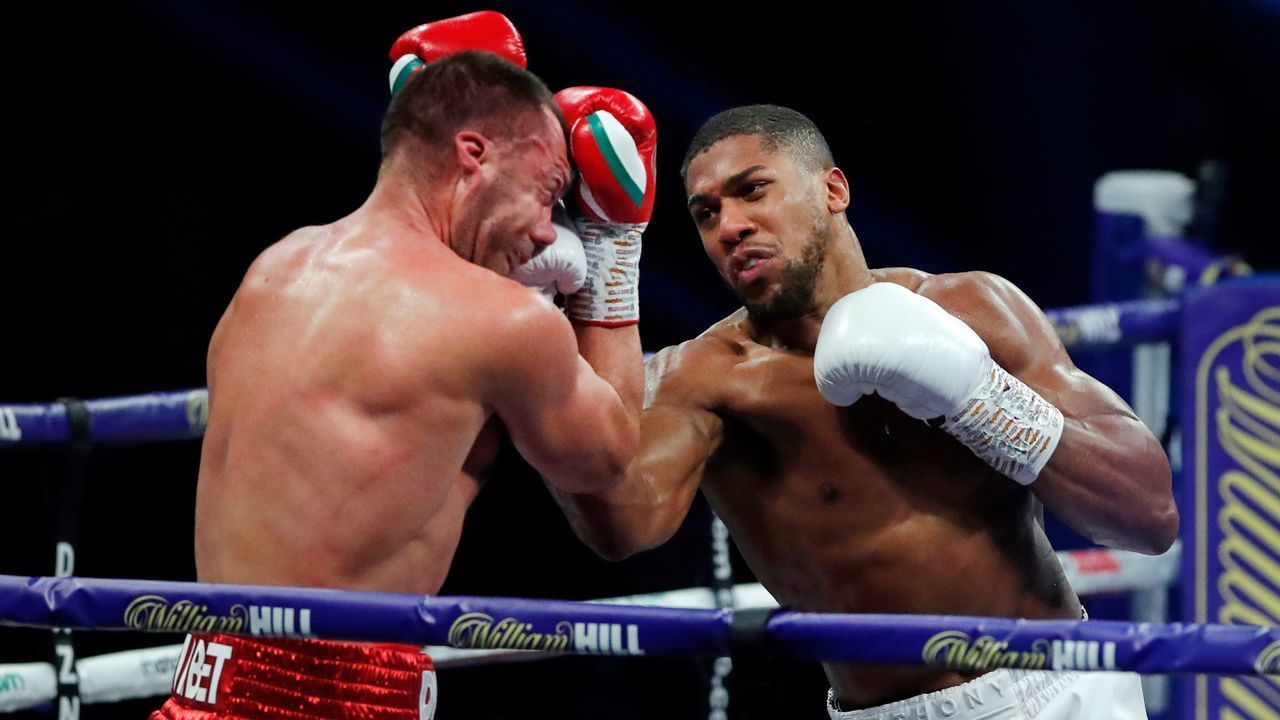Britain's Anthony Joshua (R) lands a punch on Bulgaria's Kubrat Pulev (L) during their heavyweight world title boxing match at Wembley Arena in north west London on December 12, 2020.