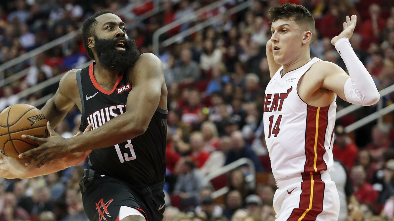 HOUSTON, TX - NOVEMBER 27: James Harden #13 of the Houston Rockets drives to the basket defended by Goran Dragic #7 of the Miami Heat and Tyler Herro #14 in the first half at Toyota Center on November 27, 2019 in Houston, Texas.