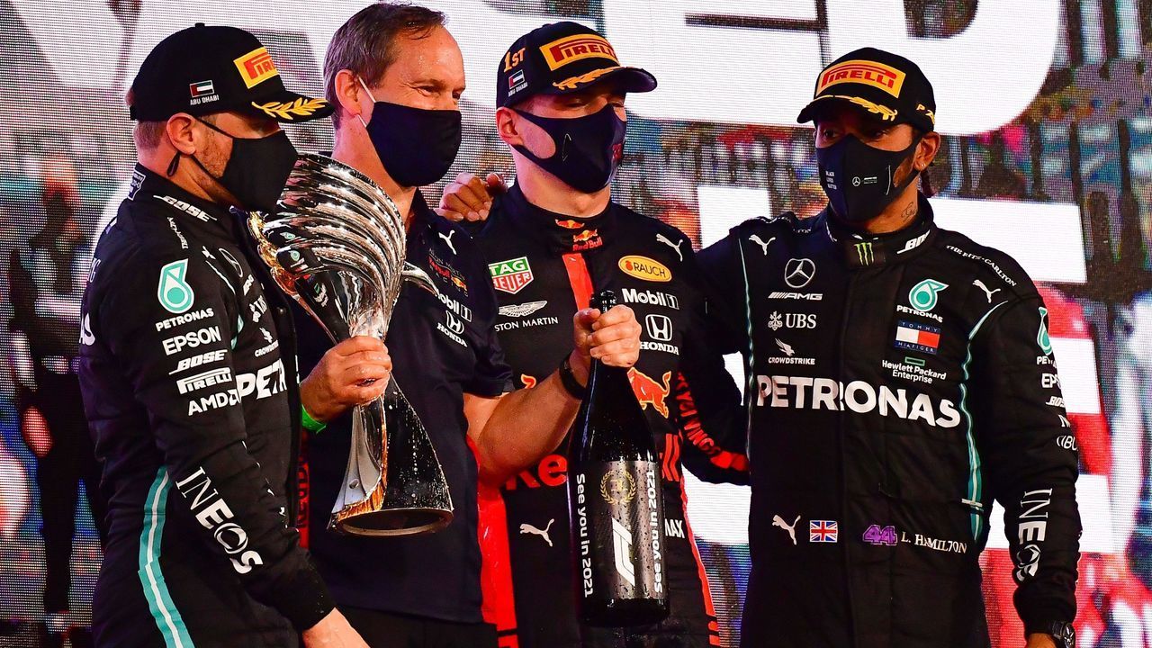 Mercedes' Finnish driver Valtteri Bottas (L) Red Bull's Paul Monaghan (2nd-L), Red Bull's Dutch driver Max Verstappen (C) and Mercedes' British driver Lewis Hamilton on the podium after the Abu Dhabi Formula One Grand Prix at the Yas Marina Circuit in the Emirati city of Abu Dhabi on December 13, 2020.