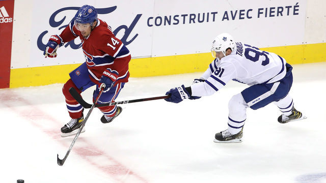 TORONTO, ONTARIO - JULY 28: Nick Suzuki #14 of the Montreal Canadiens takes the puck as John Tavares #91 of the Toronto Maple Leafs defends in the third period during an exhibition game prior to the 2020 NHL Stanley Cup Playoffs at Scotiabank Arena on July 28, 2020 in Toronto, Ontario.