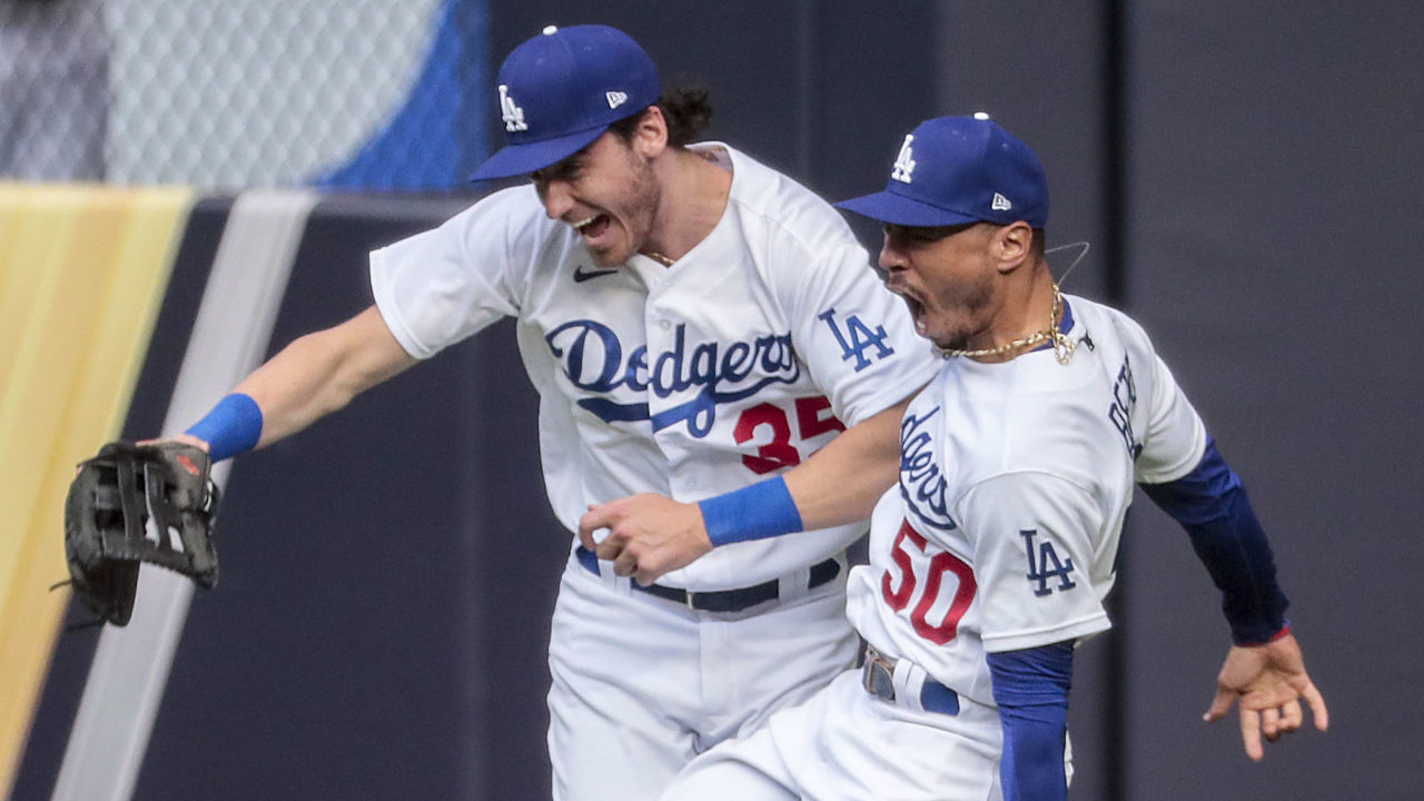 Arlington, Texas, Saturday, October 17, 2020. Los Angeles Dodgers right fielder Mookie Betts (50) celebrates with Los Angeles Dodgers center fielder Cody Bellinger (35) after leaping to catch a ball hit by Atlanta Braves designated hitter Marcell Ozuna (20) in the fifth inning in game six of the NLCS at Globe Life Field. (Robert Gauthier/ Los Angeles Times via Getty Images)