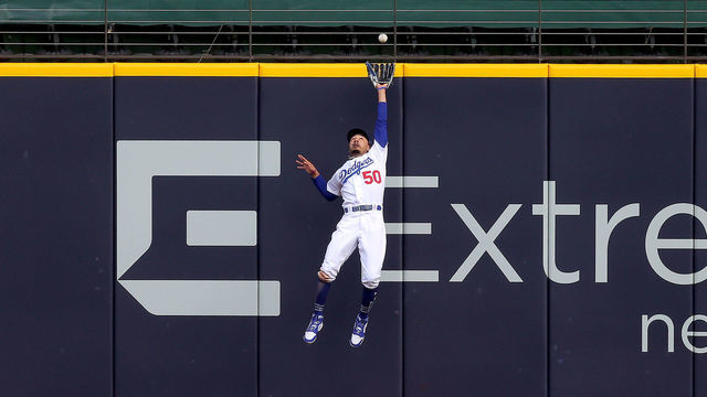 ARLINGTON, TEXAS - OCTOBER 17: Mookie Betts #50 of the Los Angeles Dodgers catches a fly ball at the wall on a hit by Marcell Ozuna (not pictured) of the Atlanta Braves during the fifth inning in Game Six of the National League Championship Series at Globe Life Field on October 17, 2020 in Arlington, Texas.