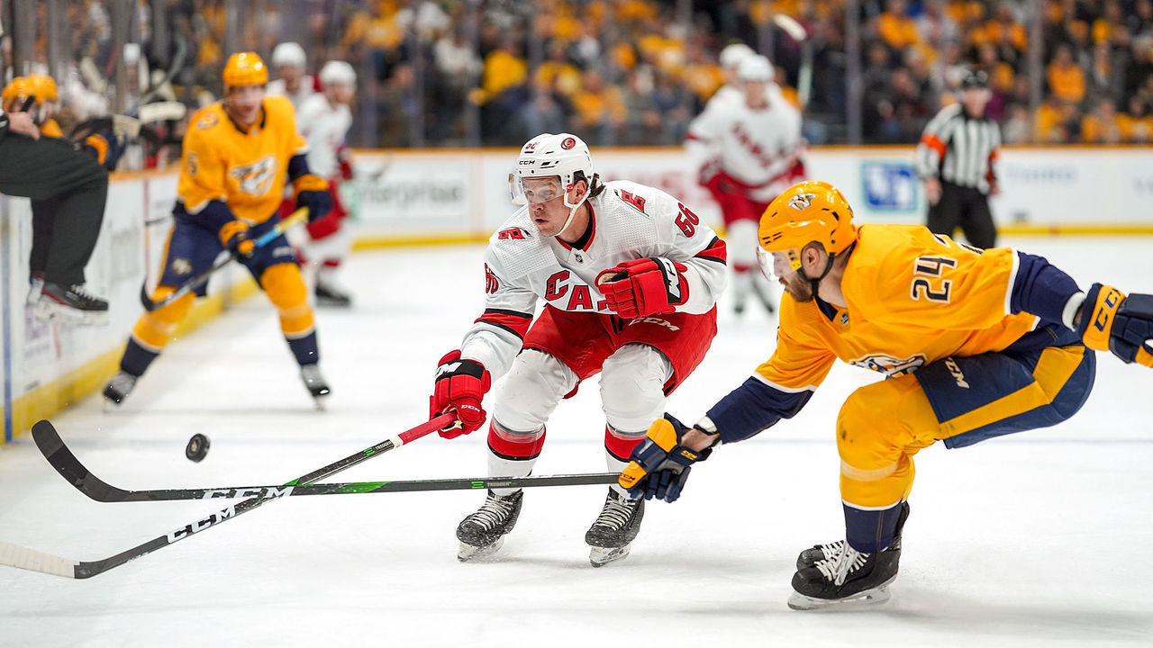 NASHVILLE, TN - FEBRUARY 18: Erik Haula #56 of the Carolina Hurricanes battles for the puck against Jarred Tinordi #24 of the Nashville Predators at Bridgestone Arena on February 18, 2020 in Nashville, Tennessee.