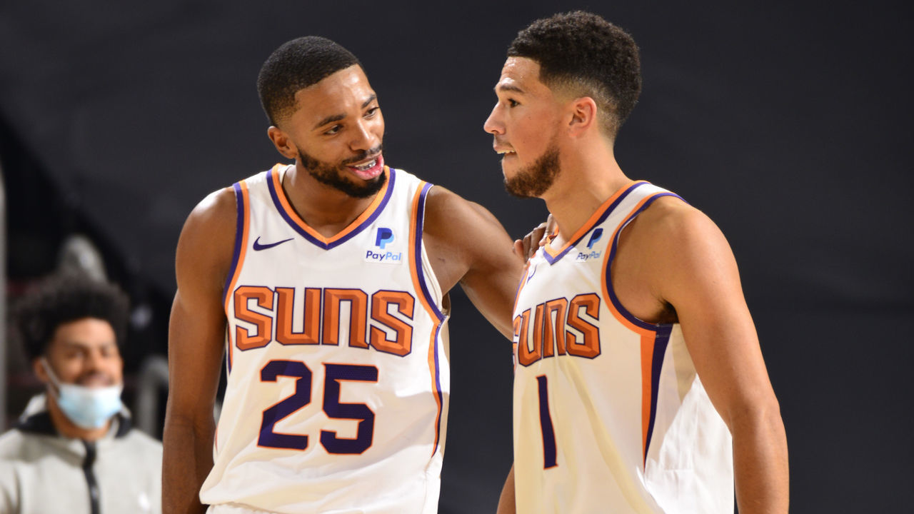 PHOENIX, AZ - DECEMBER 18: Mikal Bridges #25 and Devin Booker #1 of the Phoenix Suns share a conversation during a preseason game against the Los Angeles Lakers on December 18, 2020 at Talking Stick Resort Arena in Phoenix, Arizona. Mandatory Copyright Notice: Copyright 2020 NBAE