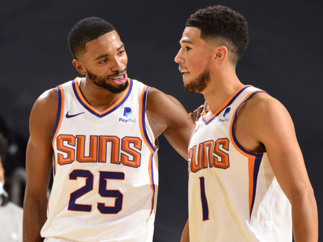 PHOENIX, AZ - DECEMBER 18: Mikal Bridges #25 and Devin Booker #1 of the Phoenix Suns share a conversation during a preseason game against the Los Angeles Lakers on December 18, 2020 at Talking Stick Resort Arena in Phoenix, Arizona. Mandatory Copyright Notice: Copyright 2020 NBAE