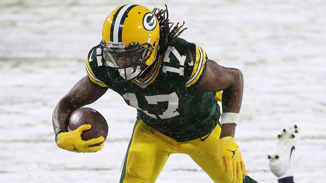 GREEN BAY, WISCONSIN - DECEMBER 27: Wide receiver Davante Adams #17 of the Green Bay Packers runs for a touchdown against cornerback Adoree' Jackson #25 of the Tennessee Titans during the first quarter at Lambeau Field on December 27, 2020 in Green Bay, Wisconsin.