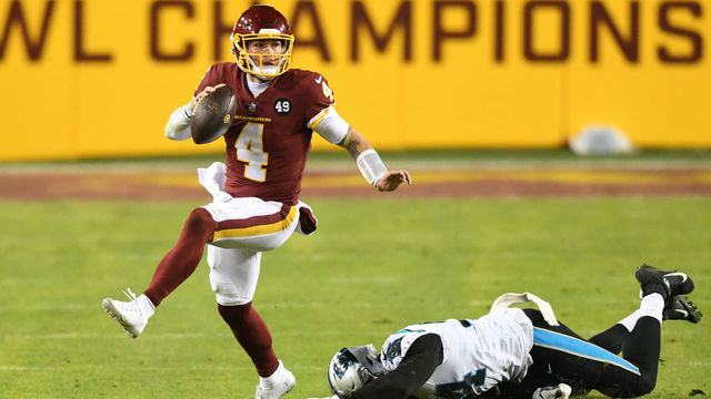 LANDOVER, MARYLAND - DECEMBER 27: Taylor Heinicke #4 of the Washington Football Team scrambles with the ball away from the tackle of Efe Obada #94 of the Carolina Panthers during the third quarter at FedExField on December 27, 2020 in Landover, Maryland.