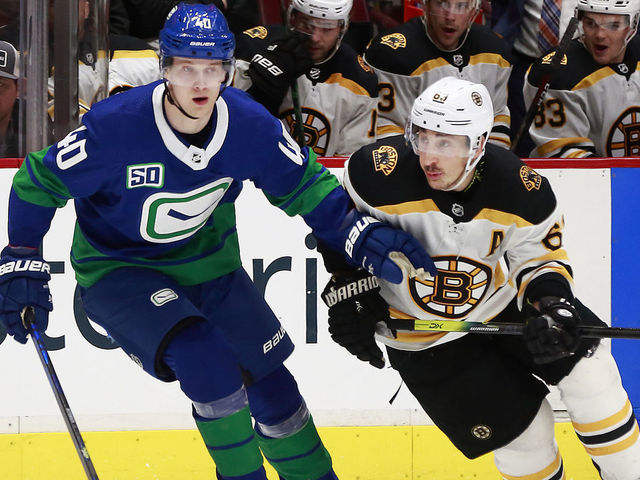 VANCOUVER, BC - FEBRUARY 22: Elias Pettersson #40 of the Vancouver Canucks skates up ice beside Brad Marchand #63 of the Boston Bruins during their NHL game at Rogers Arena February 22, 2020 in Vancouver, British Columbia, Canada. "n