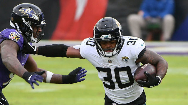 BALTIMORE, MARYLAND - DECEMBER 20: Running back James Robinson #30 of the Jacksonville Jaguars stiff arms defensive end Yannick Ngakoue #91 of the Baltimore Ravens during the first half of their game at M&T Bank Stadium on December 20, 2020 in Baltimore, Maryland.