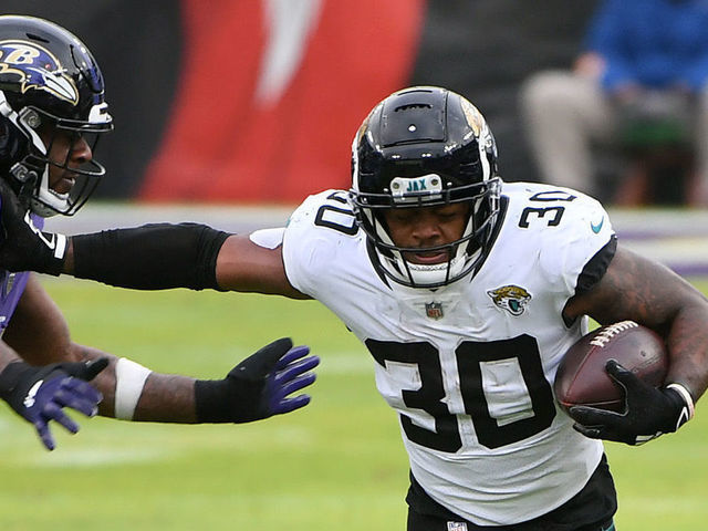 BALTIMORE, MARYLAND - DECEMBER 20: Running back James Robinson #30 of the Jacksonville Jaguars stiff arms defensive end Yannick Ngakoue #91 of the Baltimore Ravens during the first half of their game at M&T Bank Stadium on December 20, 2020 in Baltimore, Maryland.
