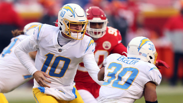 KANSAS CITY, MISSOURI - JANUARY 03: Quarterback Justin Herbert #10 of the Los Angeles Chargers hands off to Austin Ekeler #30 during the 1st half of the game against the Kansas City Chiefs at Arrowhead Stadium on January 03, 2021 in Kansas City, Missouri.