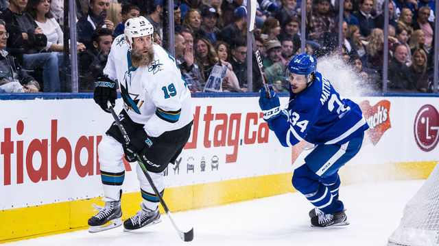 TORONTO, ON - OCTOBER 25: Joe Thornton #19 of the San Jose Sharks plays the puck against Auston Matthews #34 of the Toronto Maple Leafs during the third period at the Scotiabank Arena on October 25, 2019 in Toronto, Ontario, Canada.