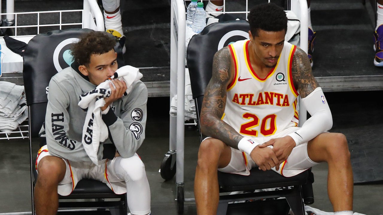 ATLANTA, GA - JANUARY 02: Trae Young #11 and John Collins #20 of the Atlanta Hawks look on from the bench during the second half against the Cleveland Cavaliers at State Farm Arena on January 2, 2021 in Atlanta, Georgia.