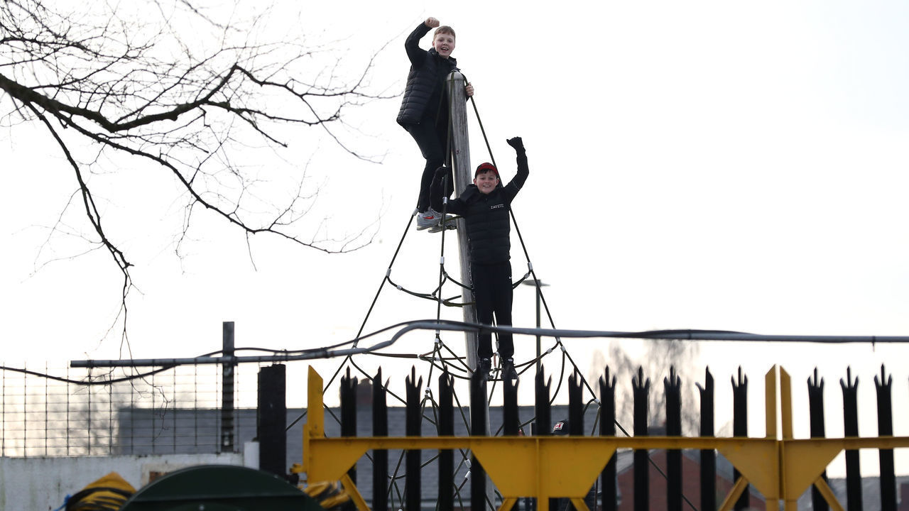 Spectators watch the game from a nearby climbing frame during the Emirates FA Cup third round match at Victory Park, Chorley.