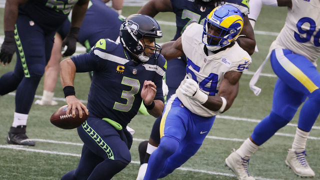 SEATTLE, WASHINGTON - JANUARY 09: Quarterback Russell Wilson #3 of the Seattle Seahawks scrambles against outside linebacker Leonard Floyd #54 of the Los Angeles Rams during the NFC Wild Card Playoff game at Lumen Field on January 09, 2021 in Seattle, Washington.