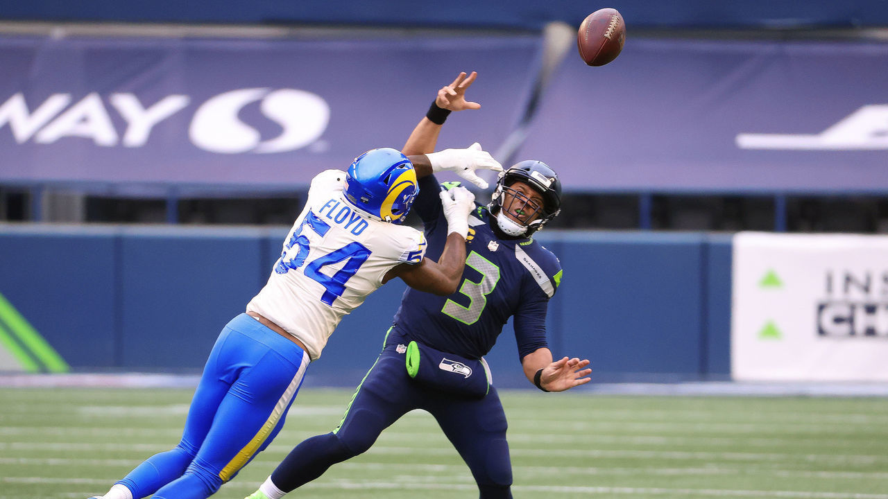 SEATTLE, WASHINGTON - JANUARY 09: Russell Wilson #3 of the Seattle Seahawks throws an incomplete pass while being hit by Leonard Floyd #54 of the Los Angeles Rams in the second quarter during the NFC Wild Card Playoff game at Lumen Field on January 09, 2021 in Seattle, Washington.