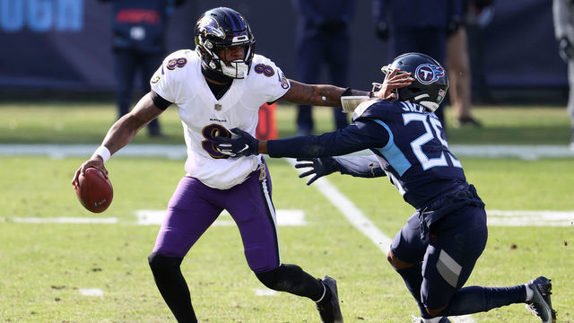 NASHVILLE, TENNESSEE - JANUARY 10: Quarterback Lamar Jackson #8 of the Baltimore Ravens attempts to break a tackle from cornerback Adoree' Jackson #25 of the Tennessee Titans during the first half of their AFC Wild Card Playoff game at Nissan Stadium on January 10, 2021 in Nashville, Tennessee.