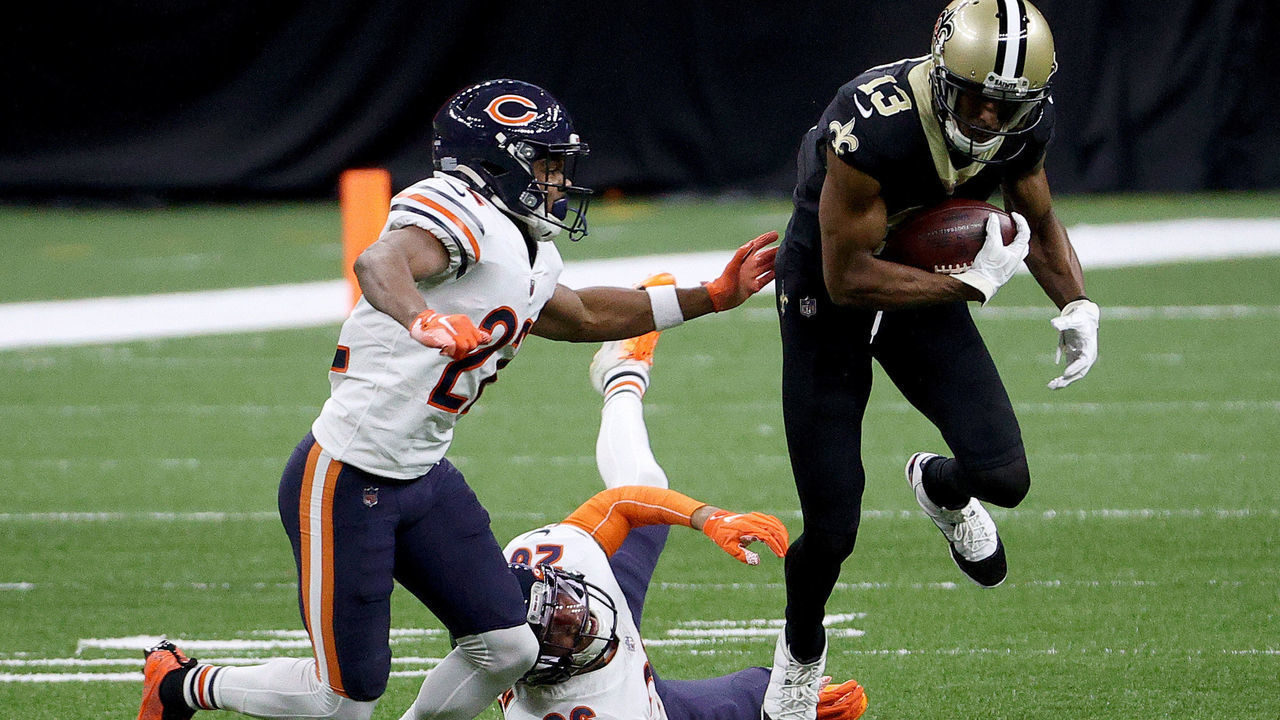 NEW ORLEANS, LOUISIANA - JANUARY 10: Michael Thomas #13 of the New Orleans Saints runs through a tackle by Deon Bush #26 and Kindle Vildor #22 of the Chicago Bears during the first quarter in the NFC Wild Card Playoff game at Mercedes Benz Superdome on January 10, 2021 in New Orleans, Louisiana.
