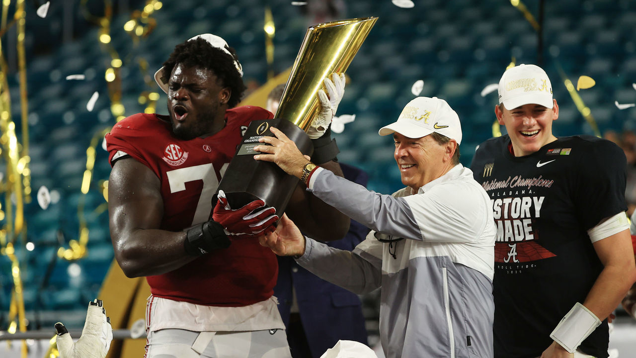 MIAMI GARDENS, FLORIDA - JANUARY 11: Alex Leatherwood #70 of the Alabama Crimson Tide holds the trophy alongside head coach Nick Saban following the College Football Playoff National Championship game win over the Ohio State Buckeyes at Hard Rock Stadium on January 11, 2021 in Miami Gardens, Florida.
