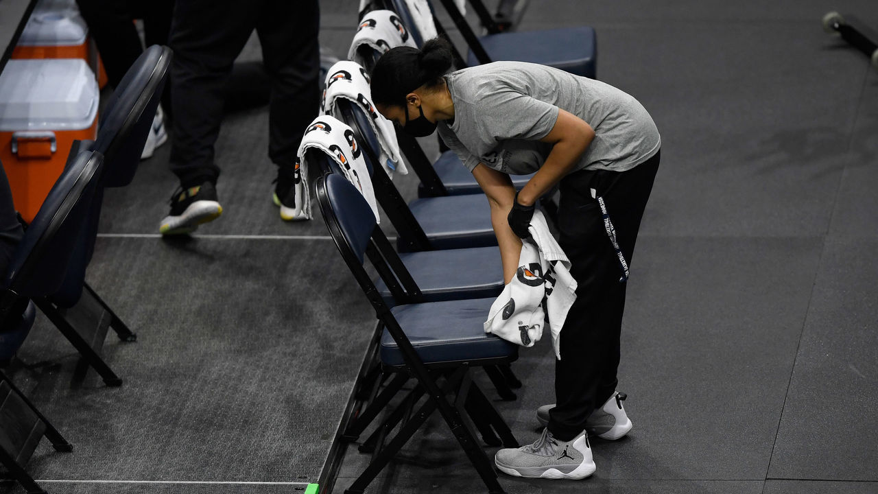 MINNEAPOLIS, MINNESOTA - DECEMBER 23: An attendant cleans the chairs used in timeouts during the fourth quarter of the season opening game between the Minnesota Timberwolves and the Detroit Pistons at Target Center on December 23, 2020 in Minneapolis, Minnesota. The Timberwolves defeated the Pistons 111-101.
