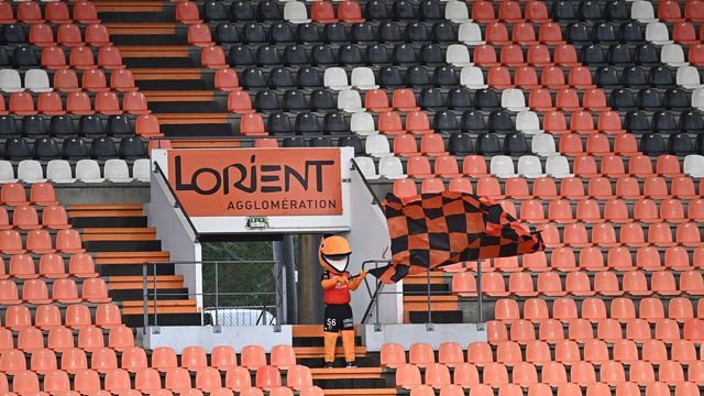 Lorient's mascott waves a flag on empty tribunes during the French L1 football match between FC Lorient and Nimes Olympique, at the Moustoir stadium in Lorient, northwestern France on December 13, 2020.