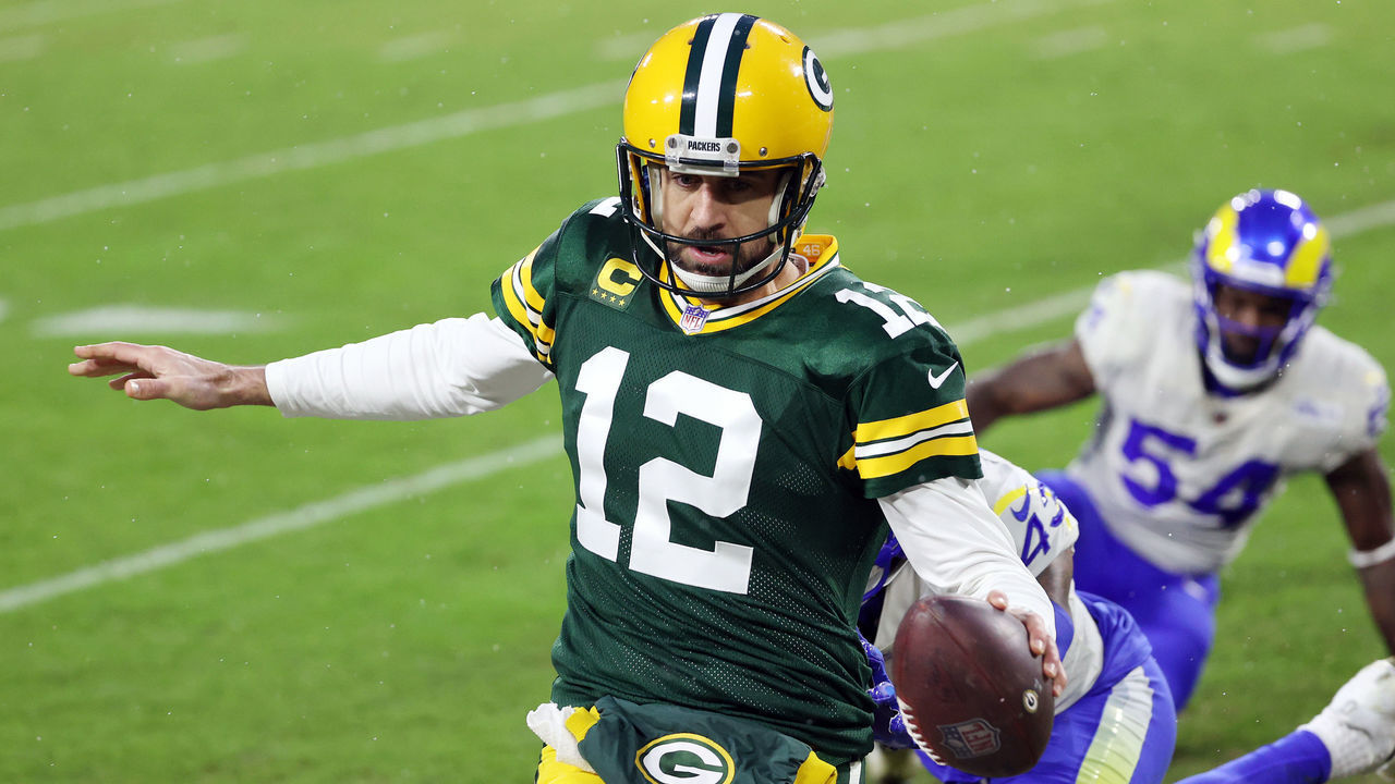 GREEN BAY, WISCONSIN - JANUARY 16: Aaron Rodgers #12 of the Green Bay Packers runs for a 1-yard touchdown in the second quarter against the Los Angeles Rams during the NFC Divisional Playoff game at Lambeau Field on January 16, 2021 in Green Bay, Wisconsin.