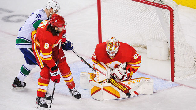 CALGARY, AB - JANUARY 18: Tanner Pearson #70 of the Vancouver Canucks takes a shot on the net of Jacob Markstrom #25 of the Calgary Flames during an NHL game at Scotiabank Saddledome on January 18, 2021 in Calgary, Alberta, Canada.