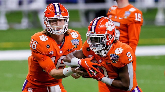 NEW ORLEANS, LA - JANUARY 01: Clemson Tigers quarterback Trevor Lawrence (16) hands the ball off to running back Travis Etienne (9) in pregame warm ups before the game between the Clemson Tigers and the Ohio State Buckeyes on January 1, 2021 at the Mercedes-Benz Superdome in New Orleans, LA.