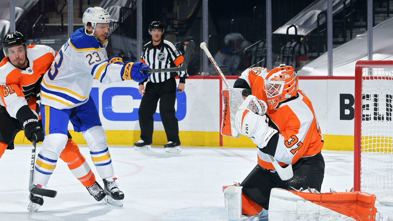 PHILADELPHIA, PA - JANUARY 19: Brian Elliott #37 and Justin Braun #61 of the Philadelphia Flyers defend against a shot by Sam Reinhart #23 of the Buffalo Sabres in the second period at Wells Fargo Center on January 19, 2021 in Philadelphia, Pennsylvania.