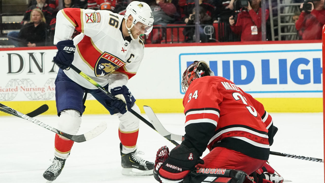 RALEIGH, NC - DECEMBER 21: Carolina Hurricanes Goalie Petr Mrazek (34) has a puck go between his legs in front of Florida Panthers Center Aleksander Barkov (16) during a game between the Florida Panthers and the Carolina Hurricanes on December 21, 2019 at the PNC Arena in Raleigh, NC.