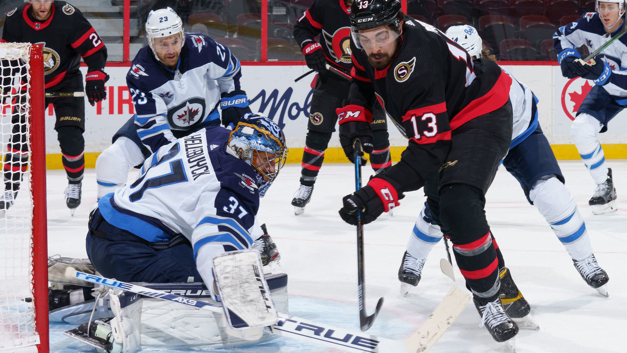 OTTAWA, ON - JANUARY 21: Connor Hellebuyck #37 of the Winnipeg Jets makes a save against Nick Paul #13 of the Ottawa Senators at Canadian Tire Centre on January 21, 2021 in Ottawa, Ontario, Canada.