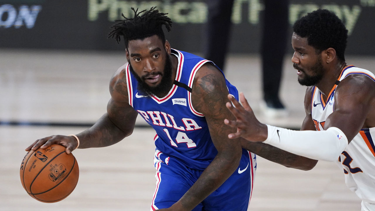 LAKE BUENA VISTA, FLORIDA - AUGUST 11: Norvel Pelle #14 of the Philadelphia 76ers handles the ball against Deandre Ayton #22 of the Phoenix Suns during the first half of a NBA basketball game at Visa Athletic Center at ESPN Wide World Of Sports Complex on August 11, 2020 in Lake Buena Vista, Florida.
