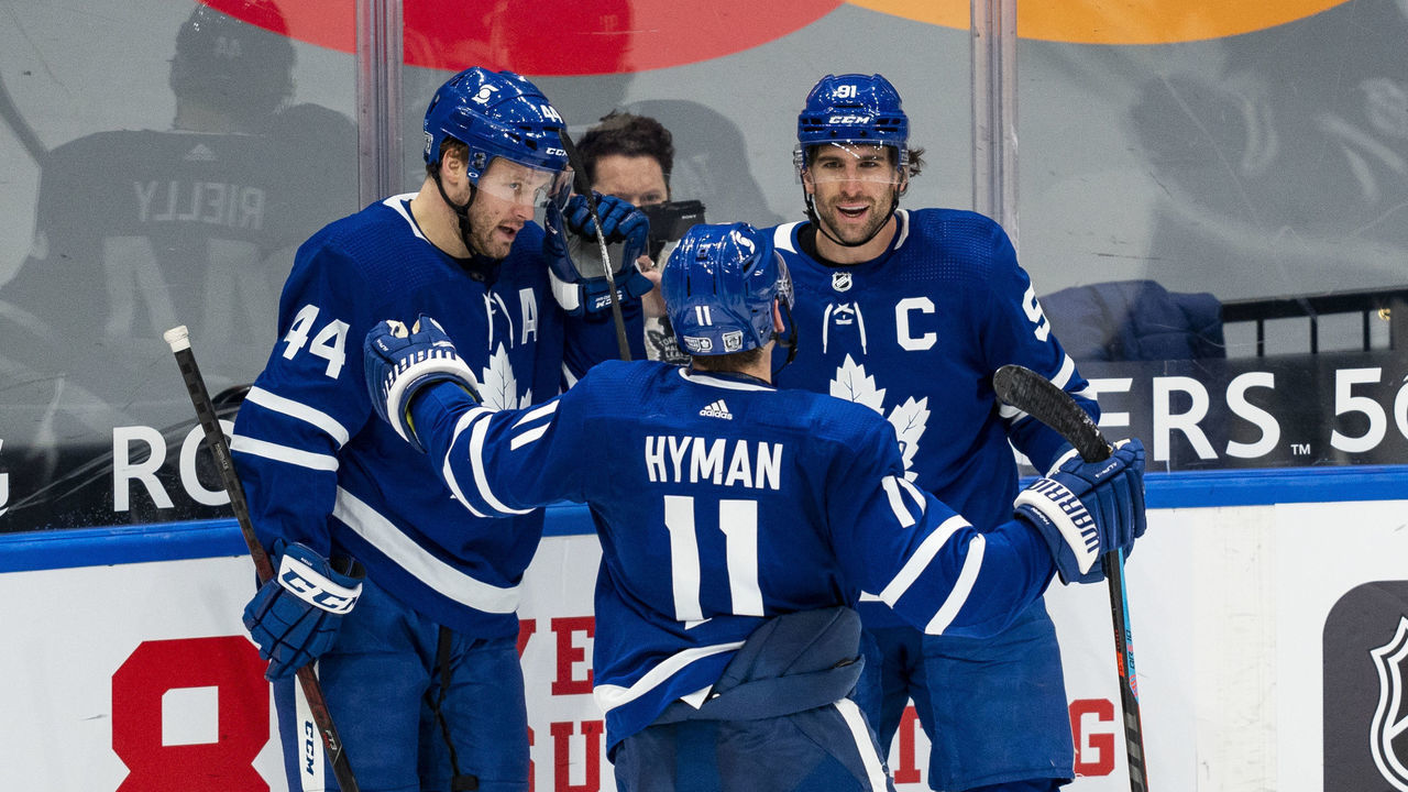 TORONTO, ON - JANUARY 22: John Tavares #91 of the Toronto Maple Leafs celebrates his goal against the Edmonton Oilers with team-mates Zach Hyman #11 and Morgan Rielly #44 during the third period at the Scotiabank Arena on January 22, 2021 in Toronto, Ontario, Canada.