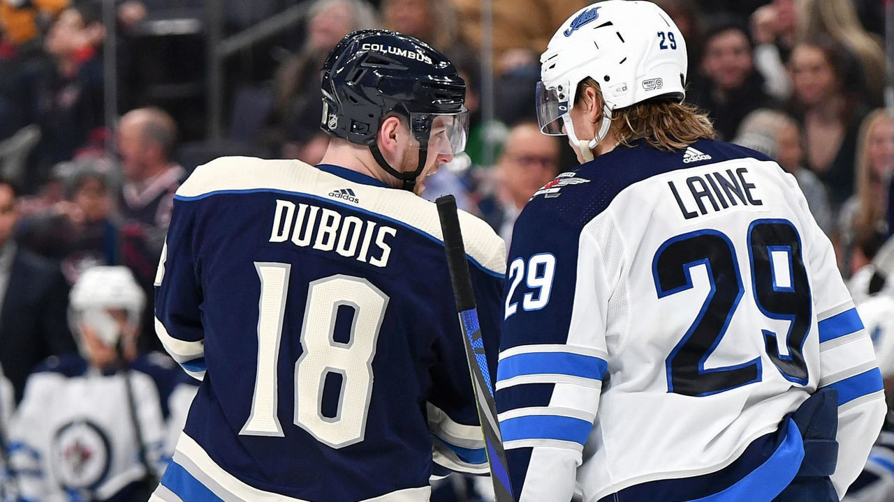 COLUMBUS, OH - JANUARY 22: Pierre-Luc Dubois #18 of the Columbus Blue Jackets talks with Patrik Laine #29 of the Winnipeg Jets during a break in action on January 22, 2020 at Nationwide Arena in Columbus, Ohio.