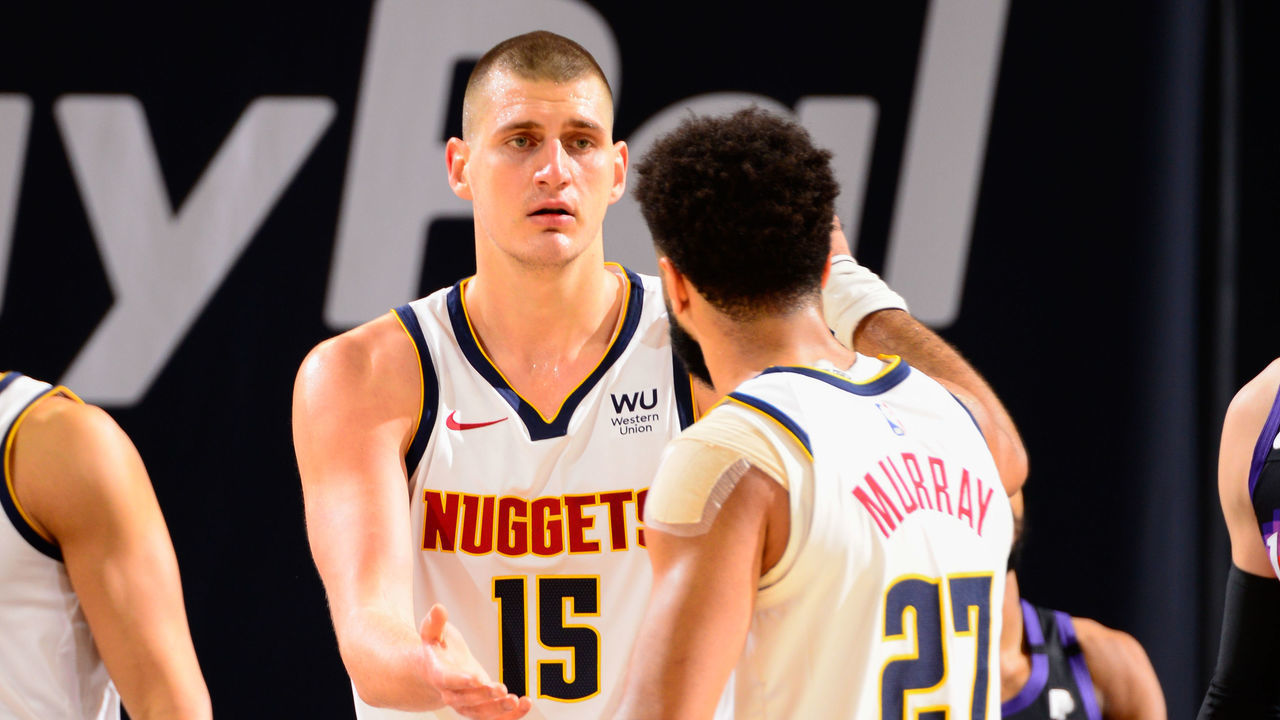 PHOENIX, AZ - JANUARY 23: Nikola Jokic #15 of the Denver Nuggets high fives Jamal Murray #27 of the Denver Nuggets during the game against the Phoenix Suns on January 23, 2021 at Talking Stick Resort Arena in Phoenix, Arizona. Mandatory Copyright Notice: Copyright 2021 NBAE