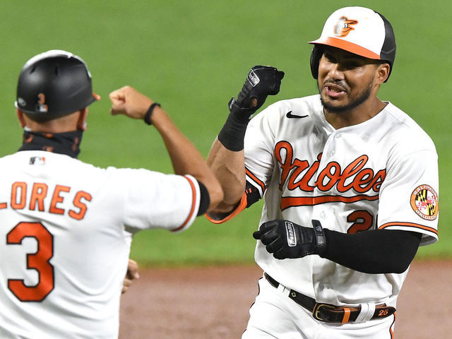 BALTIMORE, MD - AUGUST 18: Anthony Santander #25 of the Baltimore Orioles celebrates a home run with third base coach Joes Flores #3 during a baseball game against the Toronto Blue Jays at Oriole Park at Camden Yards on August 18, 2020 in Baltimore, Maryland.