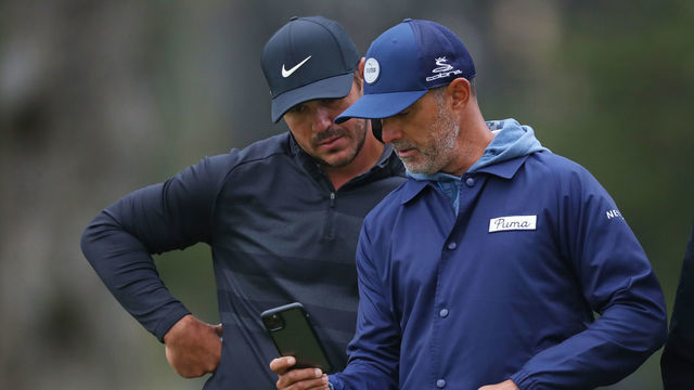 SAN FRANCISCO, CALIFORNIA - AUGUST 05: Brooks Koepka of the United States looks over a shot on the second green with his coach, Claude Harmon III, during a practice round prior to the 2020 PGA Championship at TPC Harding Park on August 05, 2020 in San Francisco, California.