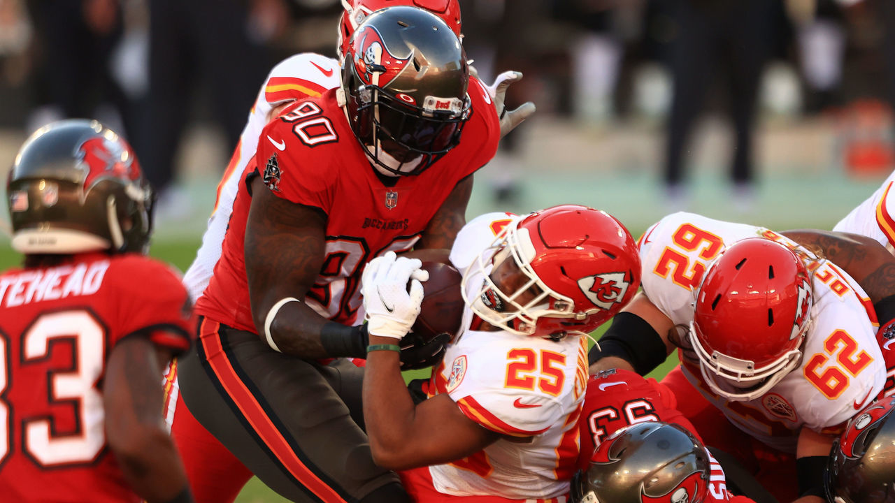 TAMPA, FLORIDA - NOVEMBER 29: Clyde Edwards-Helaire #25 of the Kansas City Chiefs attempts to break a tackle from Jason Pierre-Paul #90 of the Tampa Bay Buccaneers in the first quarter during their game at Raymond James Stadium on November 29, 2020 in Tampa, Florida.