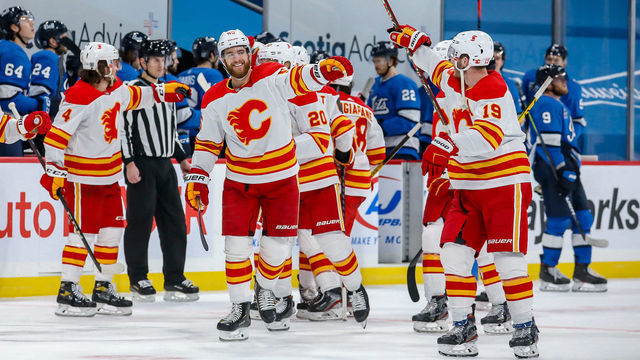 WINNIPEG, MB - FEBRUARY 1: Noah Hanifin #55 and Matthew Tkachuk #19 of the Calgary Flames celebrate a 4-3 shootout victory over the Winnipeg Jets at the Bell MTS Place on February 1, 2021 in Winnipeg, Manitoba, Canada.